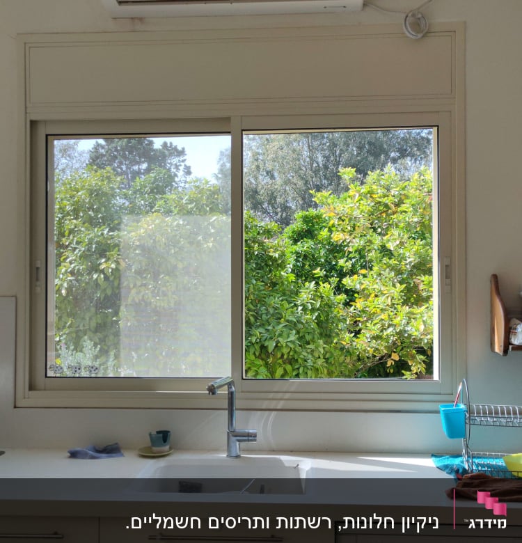 כיור מטבח עם כלים ומטלית לניקוי